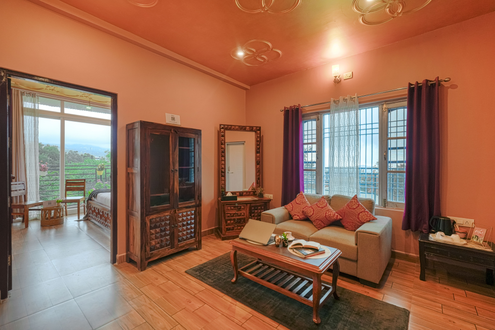 Villa room with balcony, Dharamshala hill views, wooden furniture, sofa, wardrobe, and table