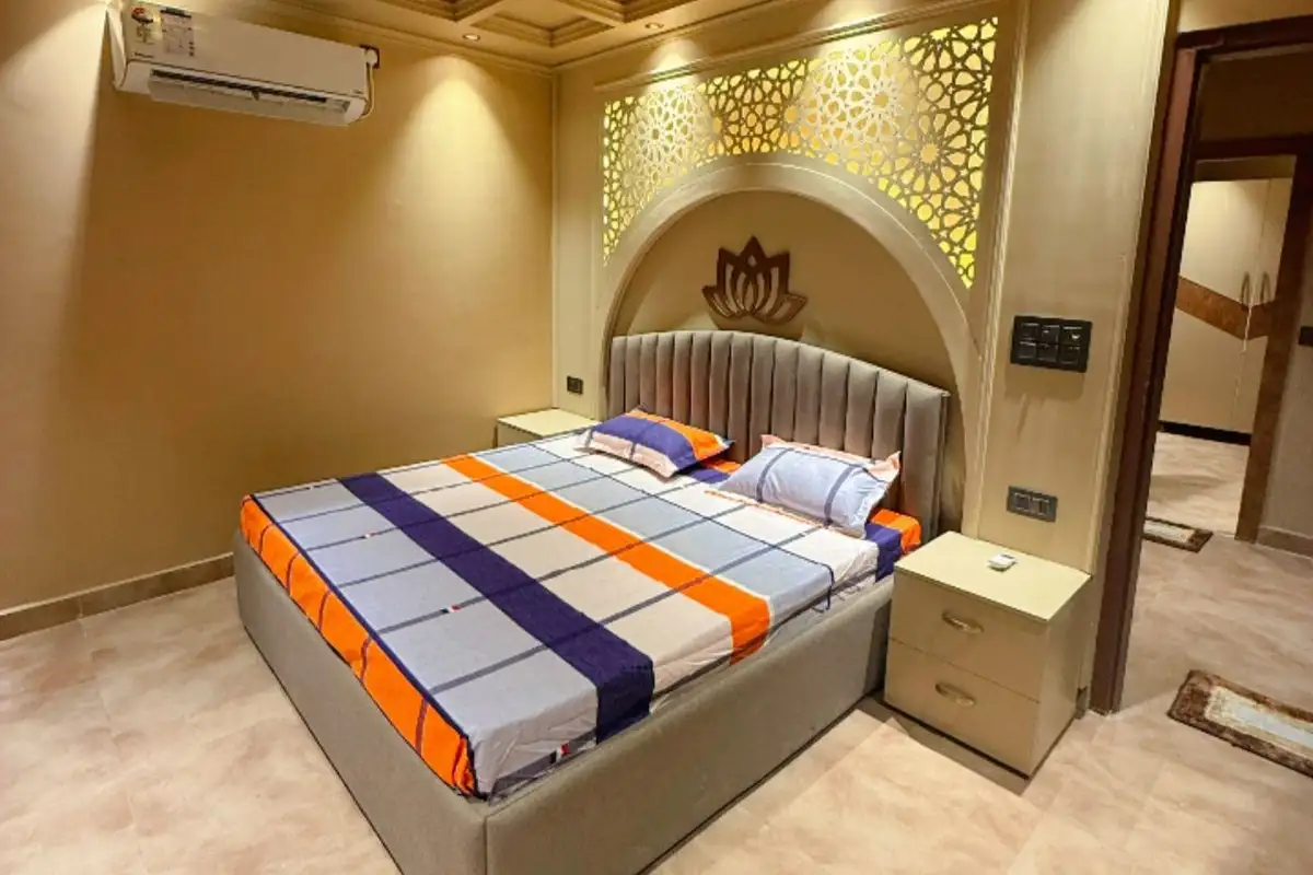 Deluxe room with double bed and side table at  Swami Jagannath Ashram in Rishikesh