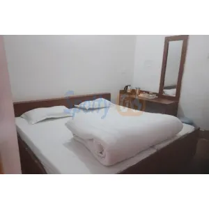 room with double bed and dressing table at Himaliya Sadan in Gangotri