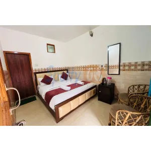 double bed with chairs at hotel Balkrishna in Gangotri