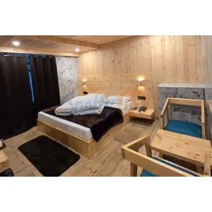 deluxe room with double bed and sitting area at Janki Guest House in Badrinath