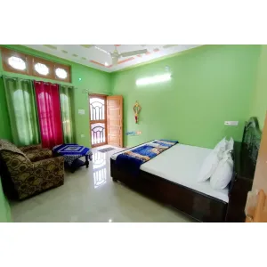 spacious room with double bed and sitting sofa at Gangotri Homestay in Barkot