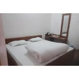 room with double bed and dressing table at Himaliya Sadan in Gangotri