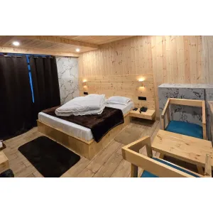 deluxe room with double bed and sitting area at Janki Guest House in Badrinath 